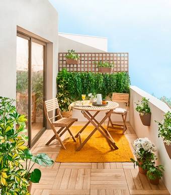 varanda decorada com mesa e cadeiras, jardim vertical, plantas e tapete laranja